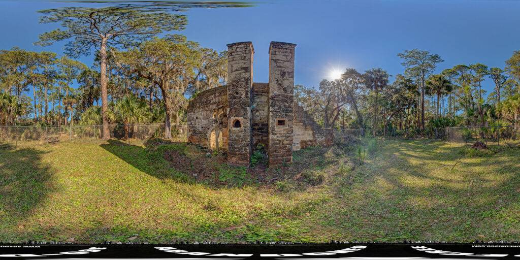 An equirectangular panoramic view of the twin chimneys at the Dummitt Plantation Mills historic site in Ormand Beach, Florida.